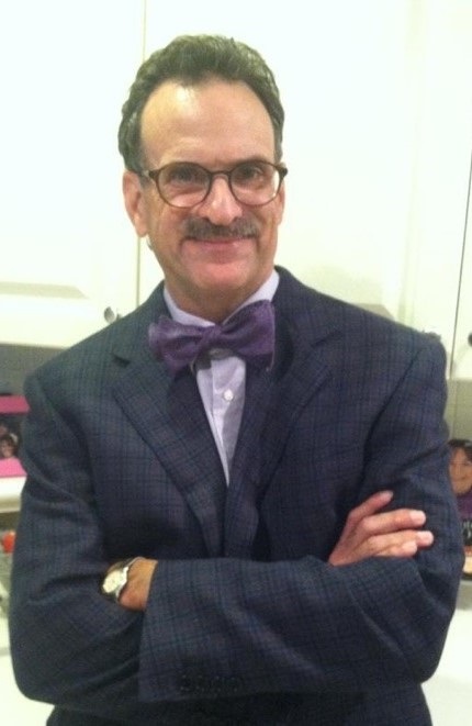 Dr. Mandel Sher in a suit with a purple bowtie. 
