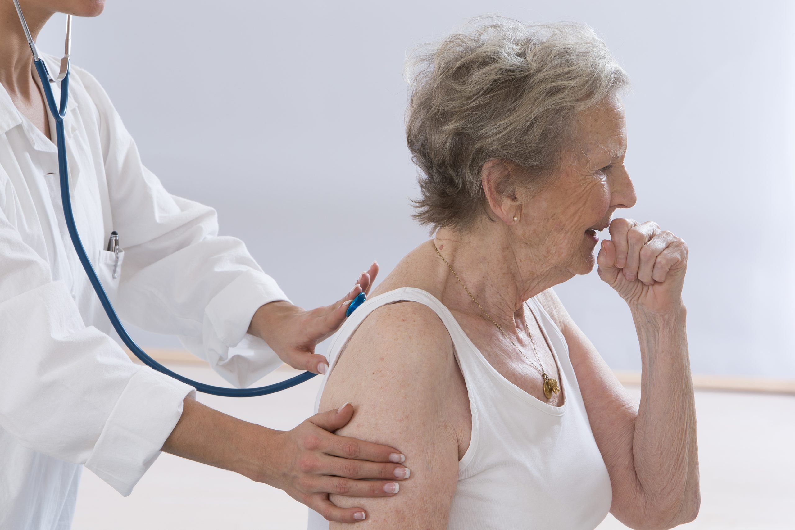 An Elderly woman suffering from Chronic Cough while being examined by a doctor