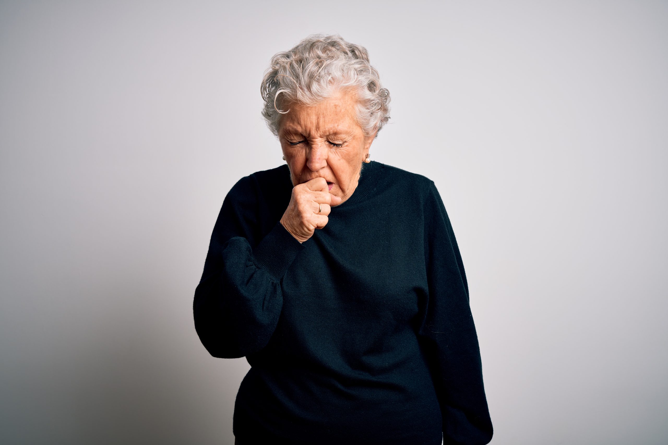 Elderly woman in black clothing, suffering from chronic cough.